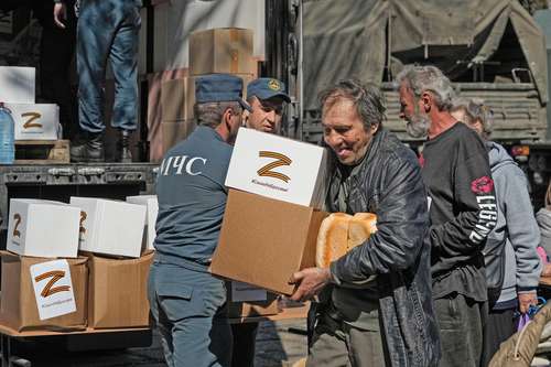 Un hombre lleva ayuda en cajas con la letra Z, que se ha convertido en símbolo del ejército ruso. La imagen fue captada en Mariupol, en un viaje organizado por el ministerio de Defensa de Rusia.