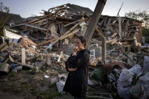 Una residente de Irpin, localidad ucrania cerca de Kiev, observa los restos de su vivienda, devastada en una ofensiva del ejército ruso. No obstante los destrozos, en su jardín algunas rosas, peonias y narcisos sobrevivieron, lo que interpretó como el comienzo de una nueva vida.