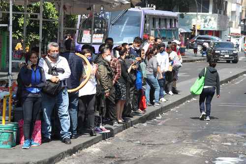 Usuarios del transporte público, algunos sin cubreboca pese a la poca distancia entre uno y otro, esperan en el paradero Pino Suárez la llegada de la unidad que los trasladará a su destino..