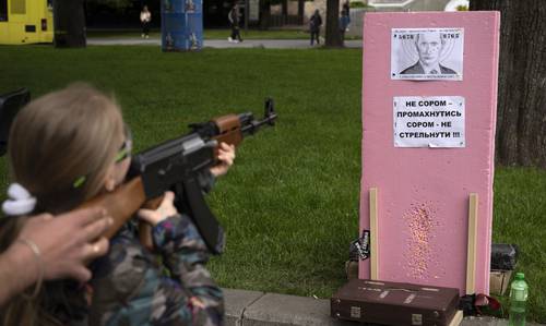 Victoria, de siete años, dispara balas de plástico a un retrato del presidente ruso Vladimir Putin, en una atracción callejera en el centro de Leópolis, Ucrania.
