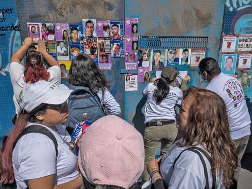 En los tapiales que rodean al lugar donde se encontraba la palma, los asistentes pegaron fotos con las facciones de sus familiares.