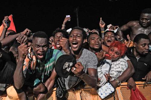 Reacción del público ante la actuación del rapero maliense Iba One con su hijo en el Festival de Música Urbana de Anoumabo en Abiyán, Costa de Marfil.