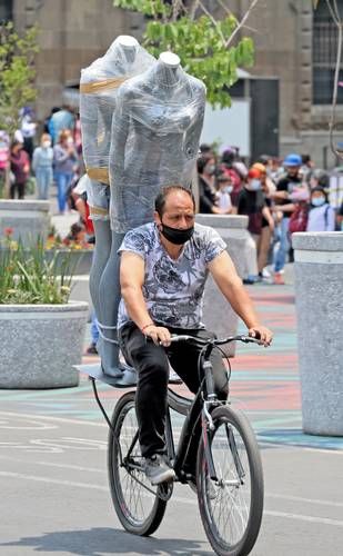 Un comerciante transporta dos maniquís en su bicicleta en la Ciudad de México.