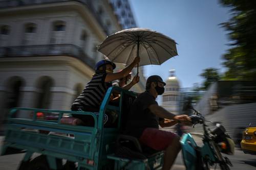 Residentes transitan cerca del Capitolio en La Habana. El gobierno de Joe Biden anunció el lunes que ampliará los vuelos a Cuba y levantará las restricciones de la era Trump sobre los envíos que pueden hacer los inmi-grantes a los habitantes de la isla.