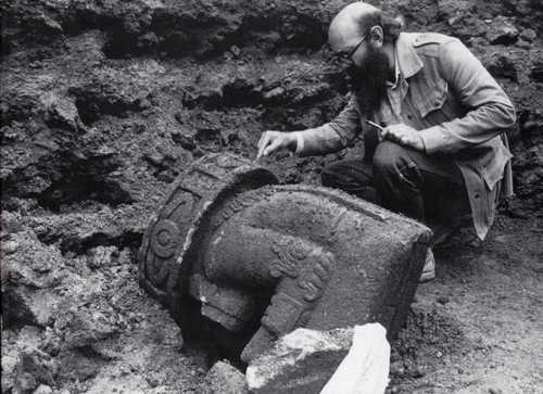 Eduardo Matos Moctezuma con la escultura del Dios Viejo, en el Templo Mayor.