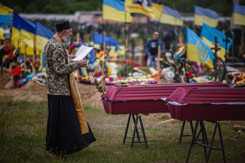 Un capellán dirige el funeral de militares ucranios asesinados en la aldea de Vil’khivka durante la invasión rusa de Ucrania, en la sección militar del cementerio número 18 de Járkov.