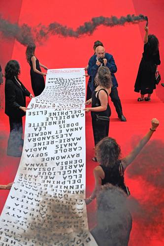 El fotógrafo francés Raymond Depardon (atrás) retrata a integrantes del movimiento feminista Les Colleuses, que sostienen la pancarta.