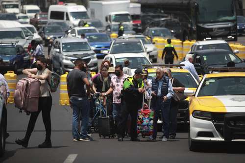BLOQUEO EN EL AICM. Taxistas que laboran en el AICM bloquearon los accesos a las terminales 1 y 2, en protesta por los servicios de aplicaciones móviles. Policías auxiliaron a los pasajeros para llegar al aeropuerto.