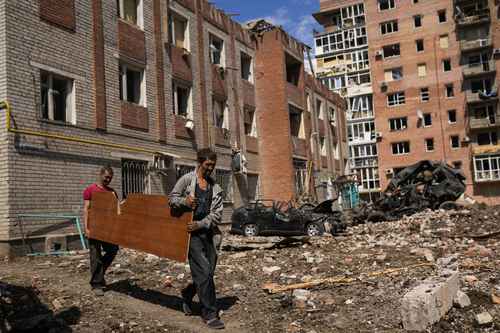 Dos hombres rescatan los materiales que pueden de las ruinas de edificios destruidos en Bakhmut, en el Donbás, en el este de Ucrania ayer.