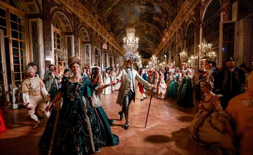 Invitados vestidos con trajes de estilo barroco caminan en el Salón de los Espejos del Palacio de Versalles como parte de la sexta edición de la noche de disfraces Fiestas Galantes.