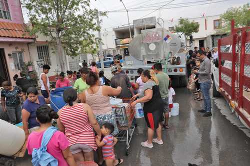 Personal de Servicios de Agua y Drenaje de Monterrey reparte el líquido, mediante pipas, a habitantes de colonias del municipio de García, Nuevo León, como parte del programa emergente para enfrentar esa problemática.