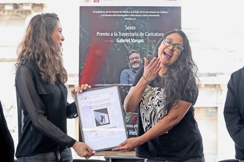 La funcionaria de Cultura, Claudia Curiel, entrega el premio a Alma Muñoz. Otros caricaturistas, colegas y amigos se reunieron en la ceremonia para recordar a Helguera.