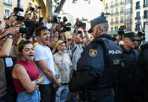Policías vigilan a manifestantes en la plaza Tirso de Molina, en Madrid. La Cumbre de la OTAN se inauguró el miércoles en medio de crecientes críticas a la agresiva política de seguridad de la alianza y los persistentes conflictos entre sus miembros.