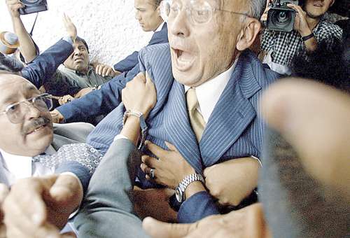 Luego de comparecer ante la fiscalía para movimientos sociales del pasado en julio de 2002, Luis Echeverría salió entre empujones y gritos de “asesino” de manifestantes.