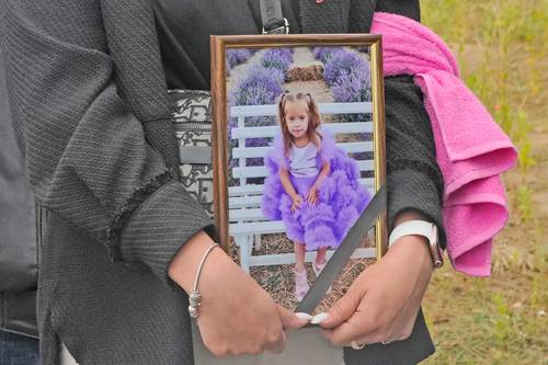 Una mujer lleva el retrato de Liza, una niña de cuatro años muerta durante un bombardeo. La imagen, durante una ceremonia fúnebre, ayer en Vinnytsia, Ucrania.