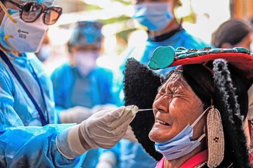 Una mujer se somete a una prueba de coronavirus antes de ingresar a un lugar visitado por el Dalái Lama, en el mercado Leh del Tíbet.