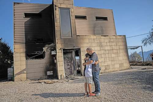 Alex Codonyer, de 55 años, abraza a su hijo Alan, de 12, tras perder su vivienda el pasado 19 de julio cerca de El Pont de Vilomara, en Cataluña.