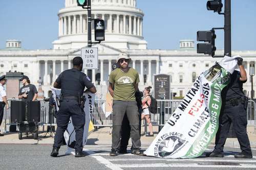 El director ejecutivo de Veteranos por la Paz, Garett Reppenhagen, fue arrestado ayer afuera del Capitolio, en Washington, cuando se manifestaba para exigir que el Congreso recorte el presupuesto del Pentágono y redirija los recursos a atender el cambio climático.