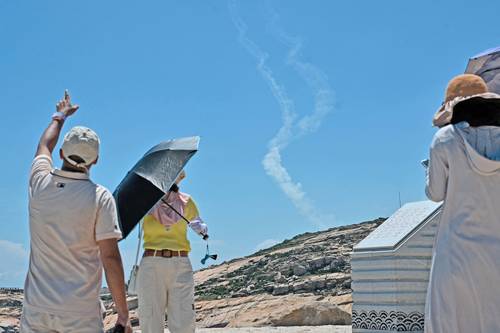 En la isla de Pingtan, uno de los puntos más cercanos de China continental a Taiwán, turistas observan las estelas de humo de los proyectiles lanzados por el ejército chino. Las maniobras se realizan un día después de la visita de Nancy Pelosi a Taipéi.