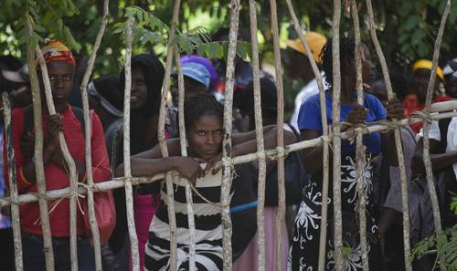 Madres de familia en Haití reciben despensas del Programa Mundial de Alimentos, pero esperan en fila al personal humanitario. Imagen de archivo.