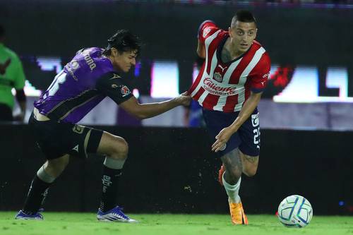 El Piojo Alvarado (25) disputa el balón.