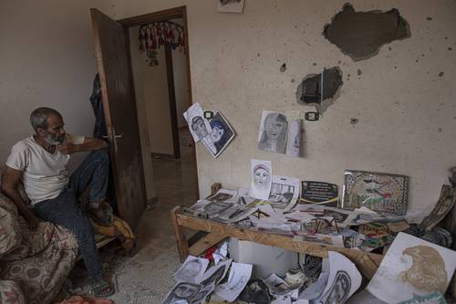 La joven artista palestina Duniana al-Amour, de 22 años, quien dibujaba para soportar la guerra, murió después de que un proyectil israelí impactara fuera de su casa el pasado 5 de agosto. Ese atentado dejó un saldo de al menos 47 palestinos muertos, incluyendo 16 menores. En la imagen, Adnan, padre de la artista, se sienta entre sus dibujos en su habitación, que fue alcanzada por un ataque israelí, al este de Khan Yunis, en el sur de la Franja de Gaza.
