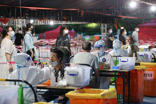  Residentes se someten a pruebas para detectar el coronavirus en un centro de recolección de hisopos en Xiamen, de la provincia de Fujian en China. Foto Afp