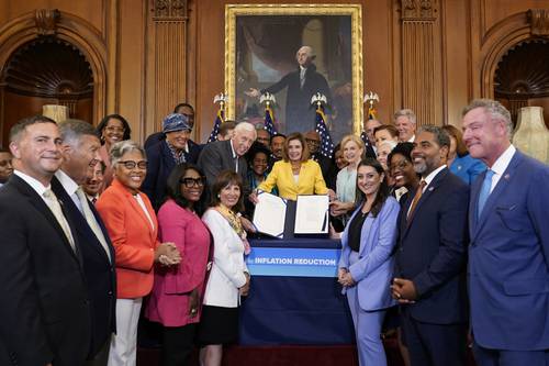 La presidenta de la Cámara de Representantes, Nancy Pelosi, rodeada de los demócratas tras la aprobación del plan de Biden.