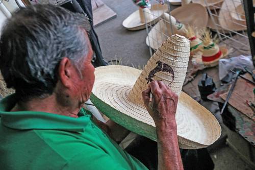 Artesanos y comerciantes esperan que sus ventas mejoren este año con los festejos de Independencia, ya que en 2021 fueron paupérrimas debido a la pandemia de covid. En la imagen, Gonzalo Peñaloza , quien junto con su familia se dedica a elaborar cada septiembre sombreros de palma, muy populares durante las celebraciones de las fiestas patrias, en la delegación San Cristóbal Huichochitlán, en Toluca, estado de México.