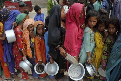 Damnificados por las inundaciones esperan recibir alimentos en la provincia de Sindh, Pakistán. El número de muertos por tres meses de lluvias históricas en ese país ascendía hasta ayer a mil 400, dijeron funcionarios.