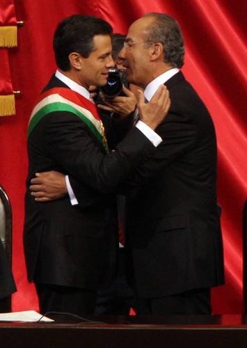 Enrique Peña Nieto, ya con la banda presidencial tras la toma de protesta como mandatario, se despide de Felipe Calderón durante la sesión del Congreso en la Cámara de Diputados el primero de diciembre de 2012.