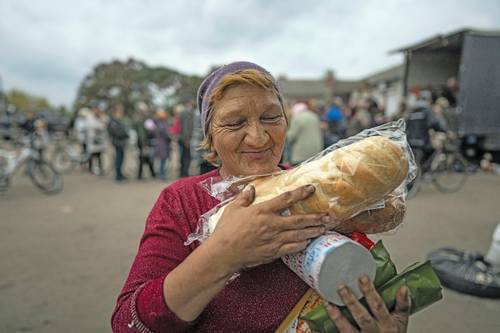 Una mujer recibe ayuda humanitaria ayer, en la ciudad de Izium, en Ucrania.