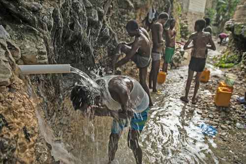 Ante el colapso de los servicios públicos en Haití, algunas personas recurren a bañarse a barrancos.