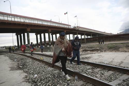  Migrantes venezolanos caminan cerca de un puente que cruza el Río Grande, luego de ser expulsados de Estados Unidos hacia Ciudad Juárez. Foto Ap