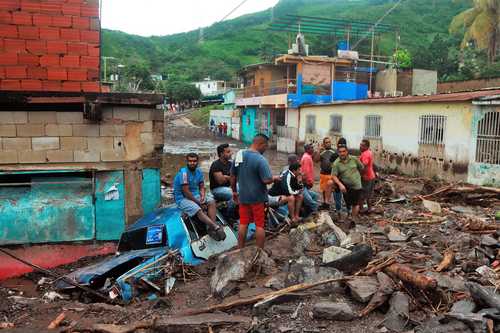 Residentes de Valle Verde, en el estado de Anzoátegui, Venezuela, permanecen entre escombros de casas destruidas tras un alud de tierra provocado por las fuertes lluvias este fin de semana.