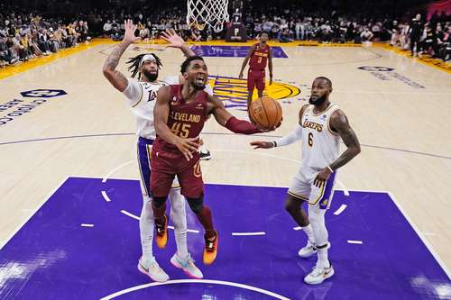 Anthony Davis (izquierda) y LeBron James (derecha), de Los Ángeles, son superados por Donovan Mitchell.