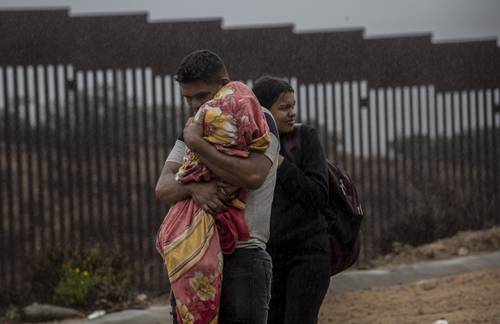 FRONTERA NORTE. Unas 50 personas de Colombia, Jamaica y otras naciones lograron cruzar el muro desde Tijuana para entregarse a las autoridades de Estados Unidos. Durante horas soportaron las bajas temperaturas, acompañadas de fuertes ráfagas de viento, hasta la llegada de agentes migratorios que llevarían a cabo el proceso.