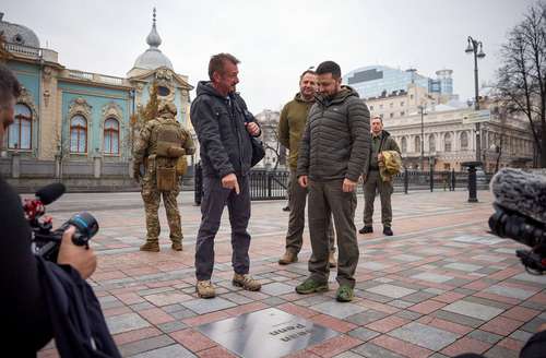 El actor y director de cine estadunidense Sean Penn señala su nombre grabado en una placa mientras habla con el presidente Volodymir Zelensky en el Callejón de Valentía en Kiev.