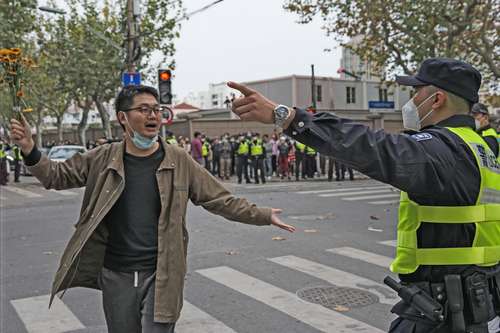 Un manifestante es confrontado por un policía durante la protesta contra las restricciones por el covid el domingo pasado en Shanghái.