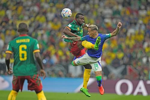 El camerunés Tolo Nouhou disputa en el aire el balón con el brasileño Antony, ante la mirada de su compañero Moumi Ngamaleu, durante el partido en el estadio Lusail. n Foto Ap