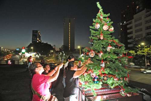 Familiares de personas desaparecidas instalaron un árbol de Navidad con las fotos de sus seres queridos, ayer en la glorieta de los Niños Héroes, en Guadalajara, Jalisco.