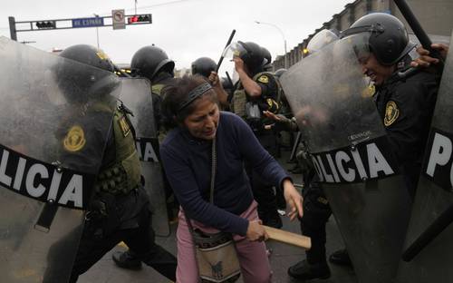Partidarios de Pedro Castillo chocan con policías que rodean la comisaría a la que fue llevado el destituido presidente de Perú el día de ayer.