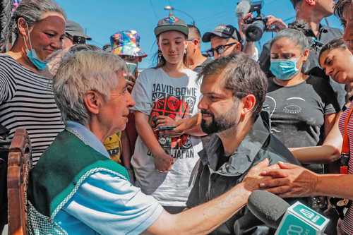 El presidente chileno, Gabriel Boric (derecha), habla con una de las víctimas del fuego.