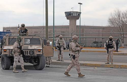 Elementos del Ejército resguardan el perímetro del Centro de Reinserción Social número 3, en Ciudad Juárez, Chihuahua, después de que la mañana del domingo hombres armados irrumpieron en el penal, donde mataron a 15 personas, dejaron a heridas a 12 y permitieron la fuga de 24 reclusos.