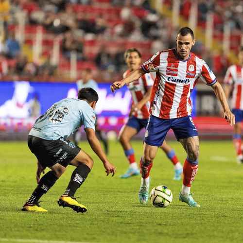 El necaxista Diego Gómez intenta frenar al delantero de los potosinos Léo Bonatini, quien marcó el segundo gol para los de San Luis.