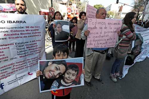 Familiares de jóvenes desaparecidas y víctimas de feminicidio se manifiestan en la CDMX, entre ellos un niño con la foto de su mamá.