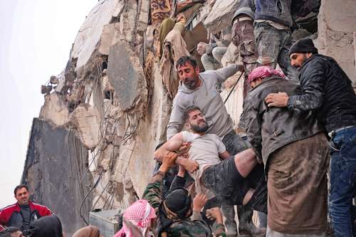 Residentes recuperana un hombre herido de los escombros de un edificio enla ciudad de Jandaris, en el noroeste de Siria.