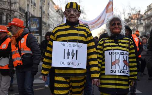 “Prisioneros del trabajo” dice un letrero de un participante en la tercera gran manifestación contra la reforma de las pensiones en Francia.