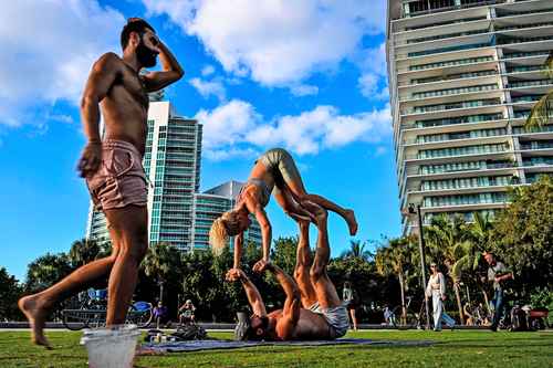 Mexicanos gastaron más de 408 millones de dólares en la compra de inmuebles en Miami durante 2022. En la foto, residentes realizan acroyoga en una playa de Florida.