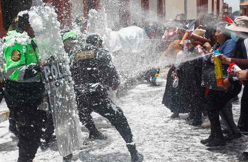 Manifestantes y policías se divirtieron ayer al empaparse con agua y espuma, durante una marcha en Puno celebrada en memoria de los muertos por la represión en Perú.